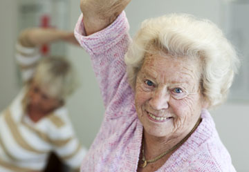 Foto: Seniorin beim Tanzen/ bei der Gymnastik.